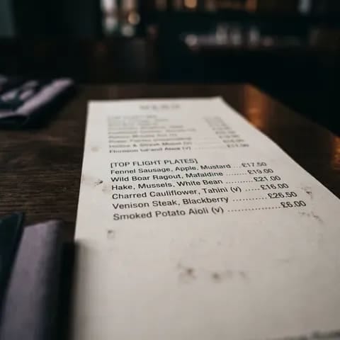 A close-up of a printed menu column showing dish names and prices
