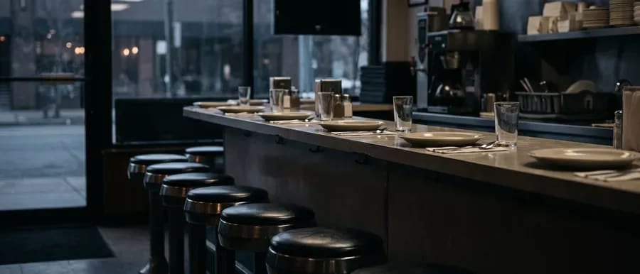 The counter and stools of a diner, set up and waiting for service